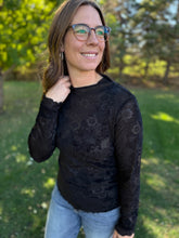 Load image into Gallery viewer, Woman wearing a black lace top and blue jeans standing outdoors with greenery in the background