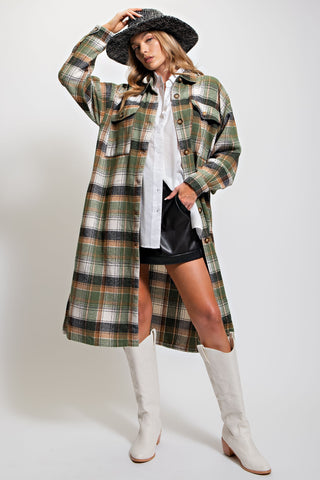 Woman wearing a plaid coat, white boots, and a hat on a white background