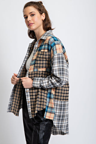 Person wearing a plaid shirt over a plain shirt on a white background