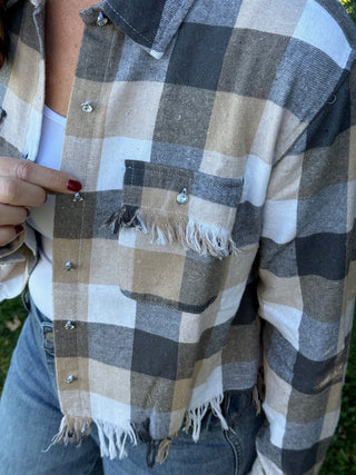 Plaid shirt with frayed edges and a hand holding it