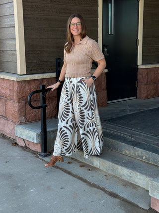 Woman standing on a sidewalk in front of a building entrance