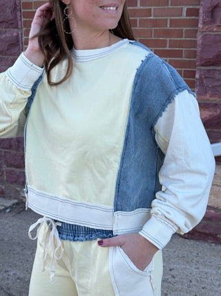 Person wearing a white and blue denim jacket with a brick wall background