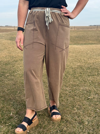 Person wearing brown pants standing in a grassy field