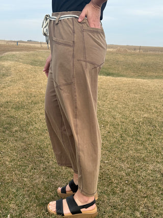 Person wearing brown pants standing on a grassy field