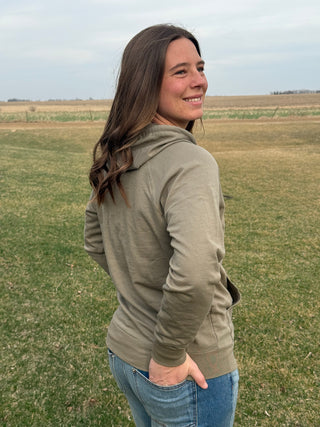 Woman wearing a green jacket standing in a field
