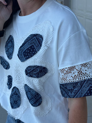 White t-shirt with blue patterned embellishments and lace details