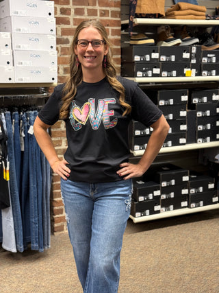 A lady wearing a LOVE graphic black t shirt.
