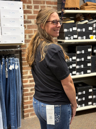 A lady wearing a LOVE graphic black t shirt.