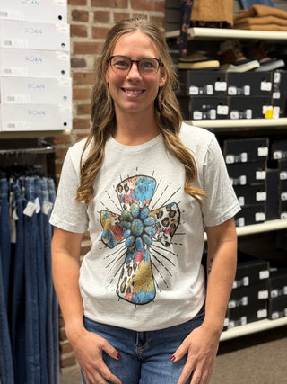 A lady wearing a grey t-shirt with a cross.