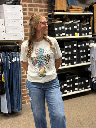 A lady wearing a grey t-shirt with a cross.