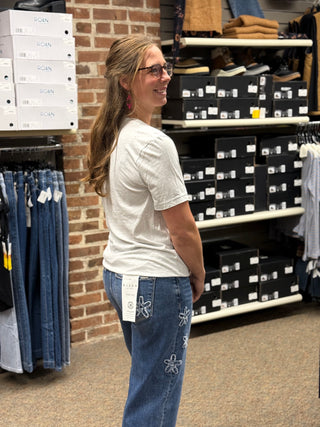 A lady wearing a grey t-shirt with a cross.