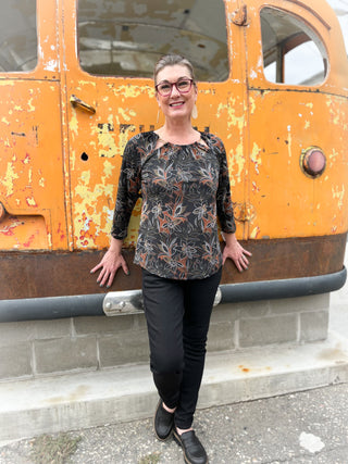 Woman standing in front of a rusted orange vehicle