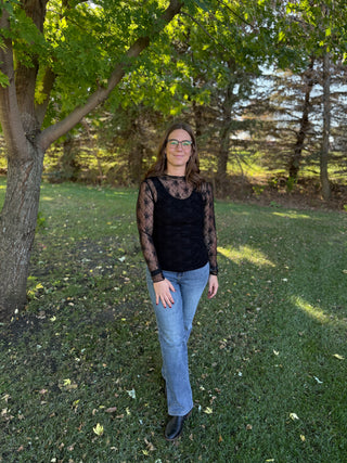 Woman standing in a park with trees and grass in the background
