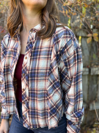 Person wearing a plaid shirt with a blurred background