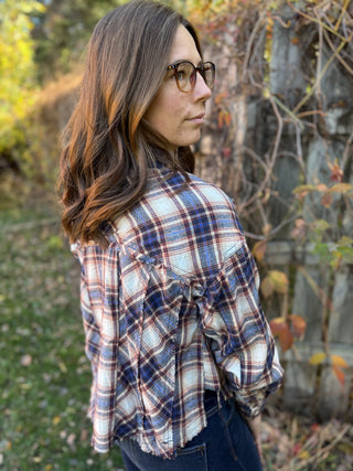 Woman wearing a plaid shirt outdoors with a natural background