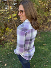 Load image into Gallery viewer, Woman wearing a purple plaid shirt standing outdoors with greenery in the background

