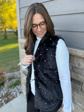 Load image into Gallery viewer, Woman wearing a black quilted vest with pearl accents in front of a house.
