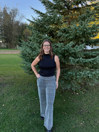 Woman standing outdoors in front of a large evergreen tree