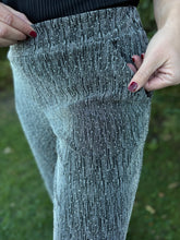 Load image into Gallery viewer, Close-up of a person wearing sparkly gray leggings with a blurred green background
