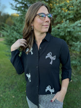 Load image into Gallery viewer, Woman wearing a black shirt with white designs outdoors
