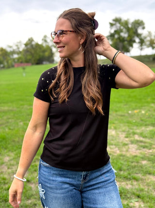 Black top with gold studs on the sleeves.