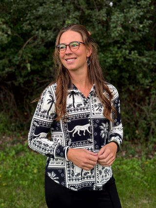 A lady wearing a black and white print blouse.