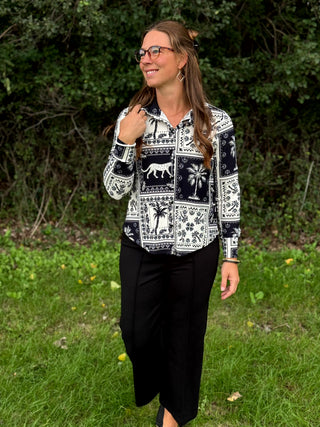 A lady wearing a black and white print blouse.