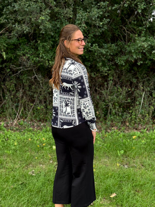A lady wearing a black and white print blouse.