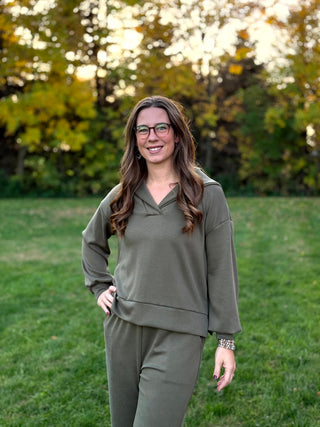  Front view of a model wearing an olive green matching set with a relaxed collared pullover and pants.

