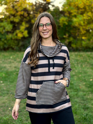 Front view of a black and taupe wide-striped pullover with narrow-striped sleeves, drawstring cowl neck, and kangaroo pocket.