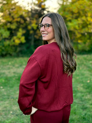 Close-up back view of a burgundy long-sleeve top with relaxed shoulders and matching pants.