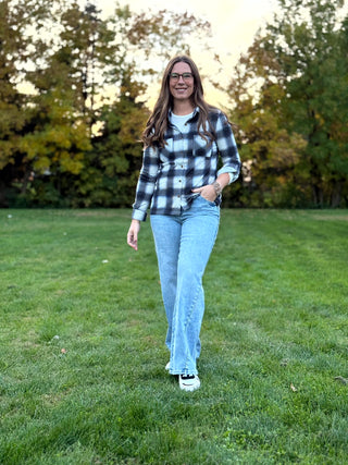 Refresh your style with our Black & White Plaid Knit Blouse. Perfect for layering with denim, this timeless button-up offers classic comfort and a polished look.