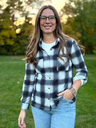 Refresh your style with our Black & White Plaid Knit Blouse. Perfect for layering with denim, this timeless button-up offers classic comfort and a polished look.