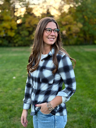 Refresh your style with our Black & White Plaid Knit Blouse. Perfect for layering with denim, this timeless button-up offers classic comfort and a polished look.