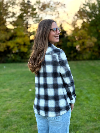 Refresh your style with our Black & White Plaid Knit Blouse. Perfect for layering with denim, this timeless button-up offers classic comfort and a polished look.