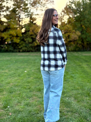 Refresh your style with our Black & White Plaid Knit Blouse. Perfect for layering with denim, this timeless button-up offers classic comfort and a polished look.