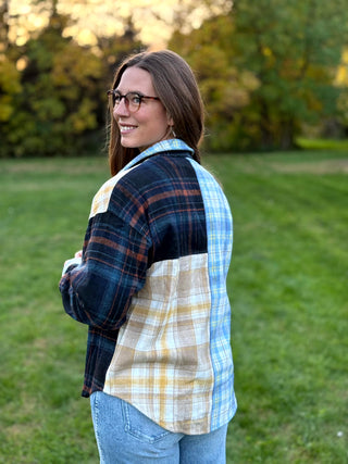 Upgrade your wardrobe with this oversized mixed media plaid shacket. Featuring a unique patchwork design, it's the ultimate cozy statement piece. Shop today!