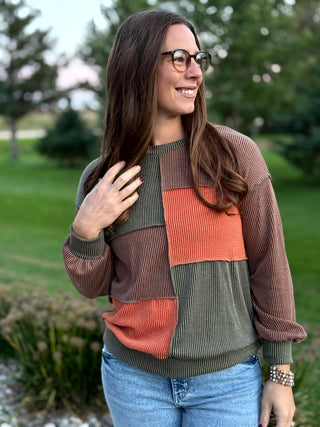 Elevate your seasonal style with this rich, earth-toned patchwork knit featuring a premium waffle texture. This breathable long-sleeve top balances effortless comfort with a bold, modern aesthetic for a versatile look that transitions from coffee dates to cozy evenings. Stay warm without the bulk in this must-have autumn staple.