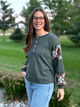 Elevate your everyday style with this uniquely crafted olive Henley featuring eye-catching plaid patchwork sleeves. Its ultra-soft fabric and relaxed fit provide the perfect blend of rustic charm and modern comfort.