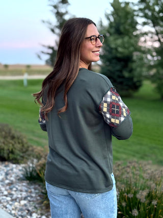 Elevate your everyday style with this uniquely crafted olive Henley featuring eye-catching plaid patchwork sleeves. Its ultra-soft fabric and relaxed fit provide the perfect blend of rustic charm and modern comfort.