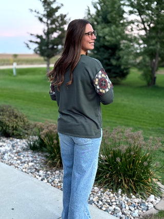 Elevate your everyday style with this uniquely crafted olive Henley featuring eye-catching plaid patchwork sleeves. Its ultra-soft fabric and relaxed fit provide the perfect blend of rustic charm and modern comfort.