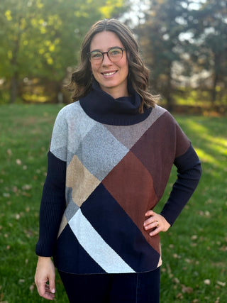 Front view of the geometric colorblock sweater with a navy cowl neckline and long ribbed sleeves.