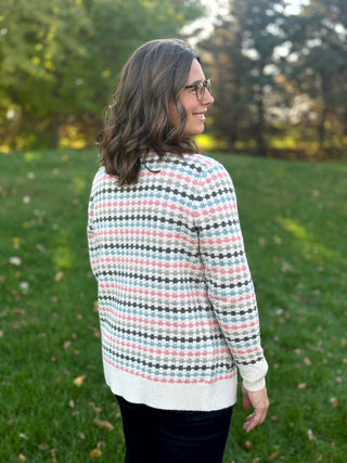 Close-up back view of the patterned knit cardigan, showing long sleeves, cream ribbed cuffs, and a wide ribbed hem.