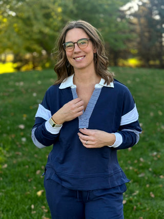 Front view of navy pullover with white collar, striped split neckline, and relaxed fit.
