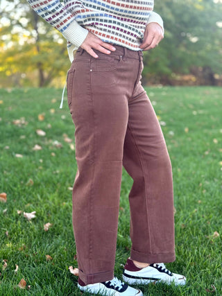 Side view of brown wide-leg jeans showing the relaxed fit, hip pocket, and cuffed hems.