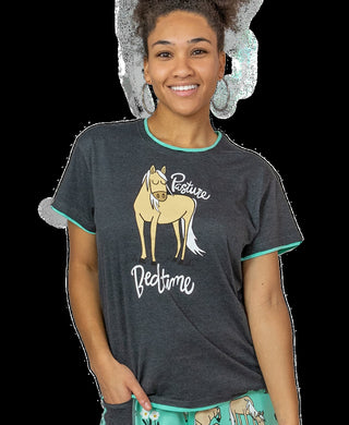 Woman wearing a dark gray t-shirt with a horse graphic and text, on a plain background