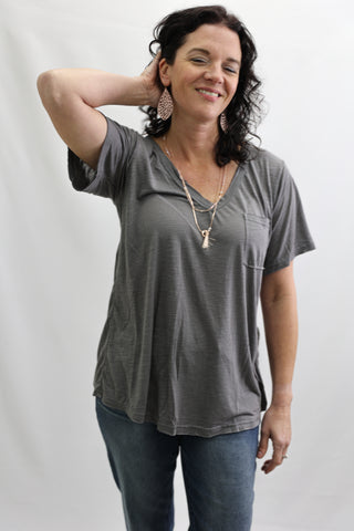 Woman wearing a gray t-shirt and blue jeans against a white background