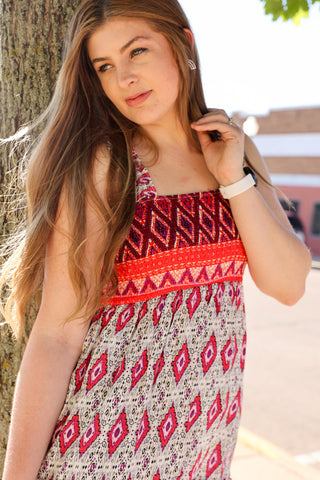 Woman wearing a patterned dress standing next to a tree
