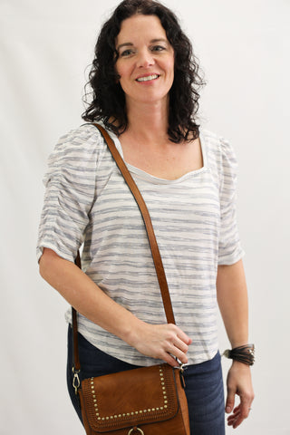 Woman holding a brown leather bag against a white background