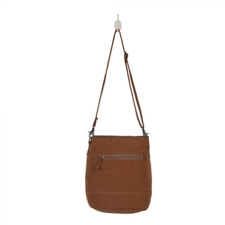 Patterned bag with brown strap and gray base on a white background